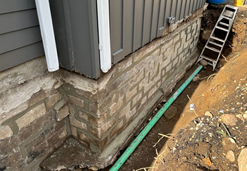 Exterior cement foundation repointed with mortar and repaired outside